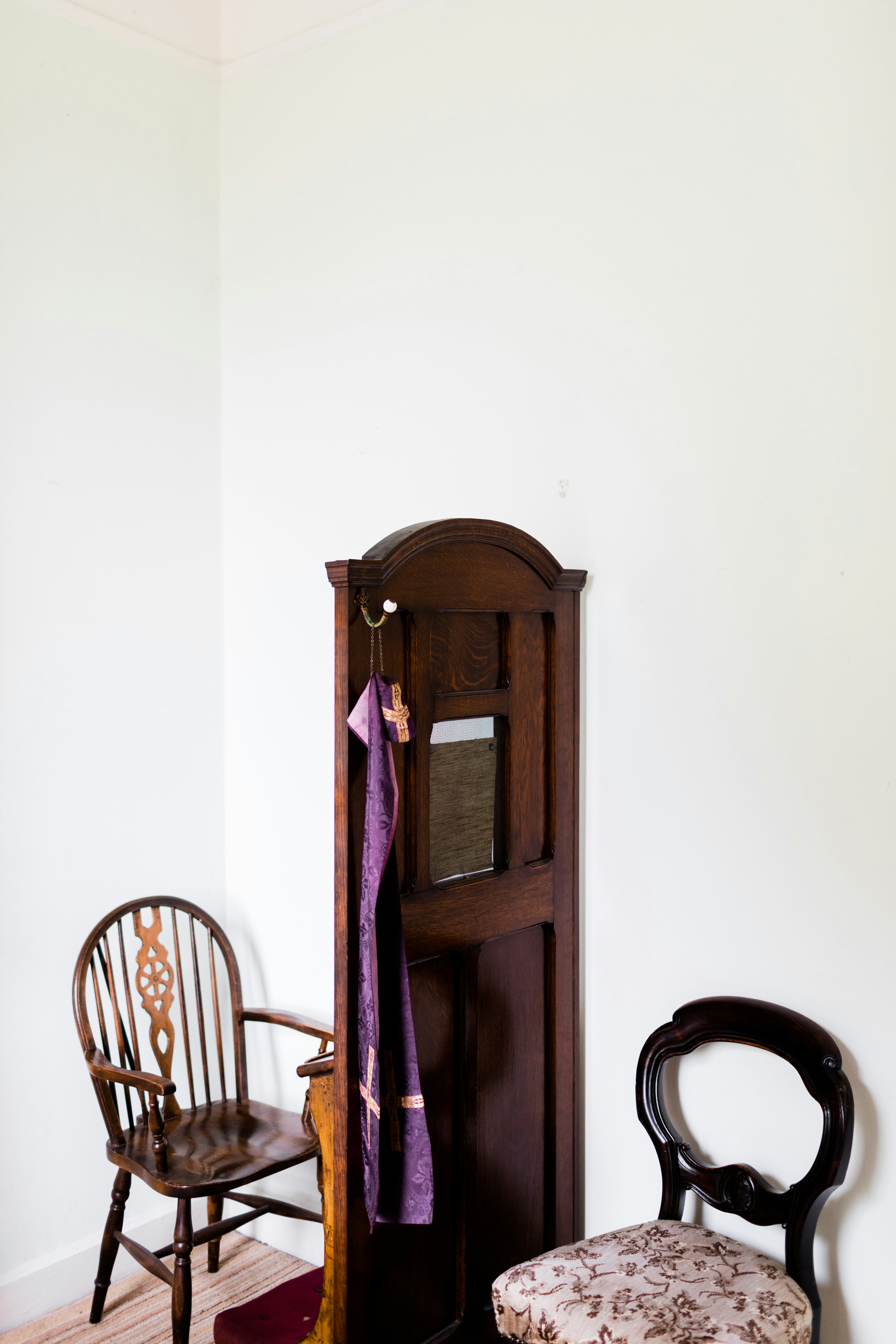 brown wooden cabinet beside brown wooden windsor armchair